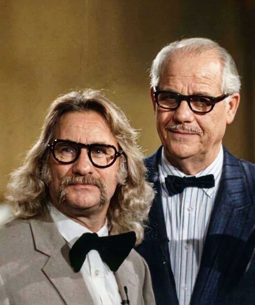 Zwei Männer in Kostümen beim Karneval in Köln, einer mit Brille und Schnurrbart, der andere mit weiß.