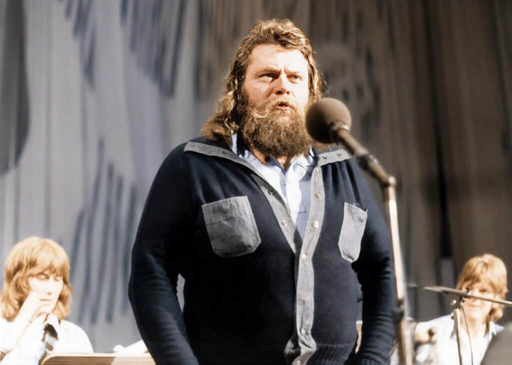 Bärtiger Mann singt auf der Bühne ins Mikrofon