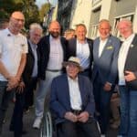 Ludwig Sebus im Rollstuhl umgeben von Weggefährten auf der Straße