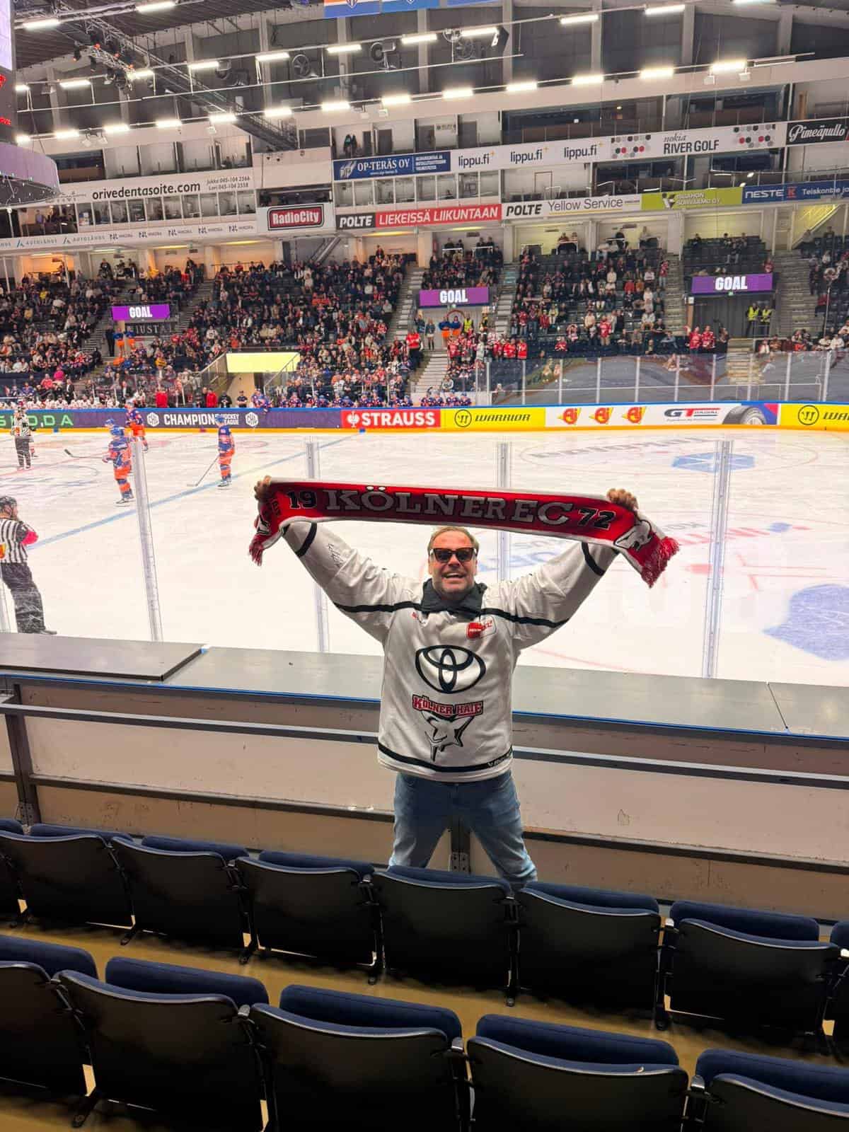 Mann mit Fanschal bei einem Eishockeyspiel im Stadion