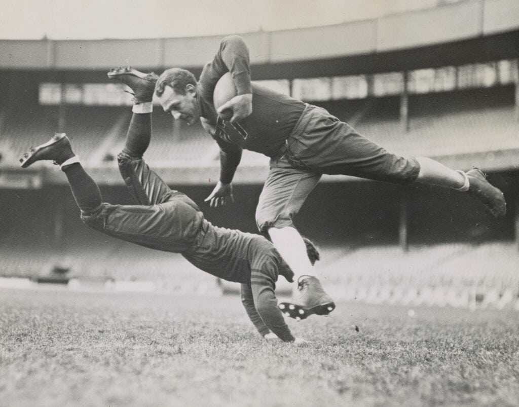 Two football players in a tackle during a game at the stadium.