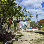 Ecovillage community area with tents, murals, and natural surroundings.