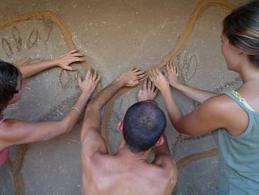 People drawing hearts on a wall with their hands at Yesh Meain Farm.