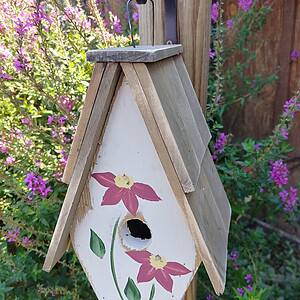 A Framed Bird House with Hand-Painted flowers and Wood Roof