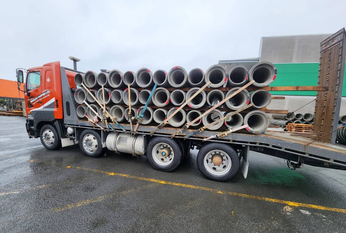 Large truck transporting concrete pipes for construction projects in New Zealand.