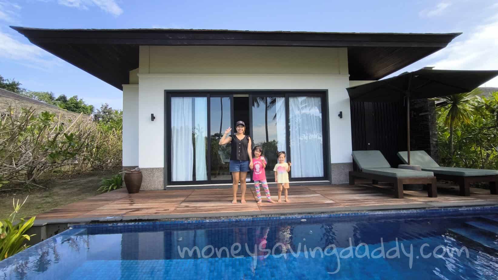 Relaxing family by the pool at modern house with sliding glass doors and outdoor lounge area.