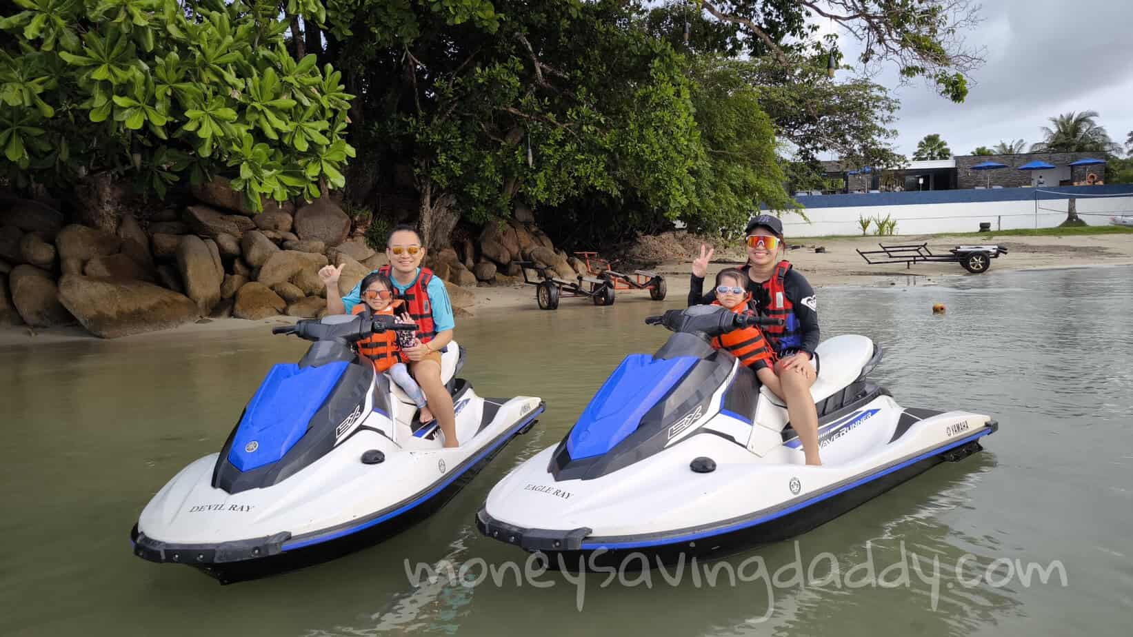 Jet skis on the water with two adults and children enjoying a fun outdoor activity.