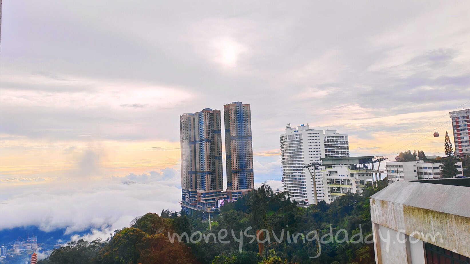 A modern city skyline with tall skyscrapers and lush greenery under a cloudy sky.