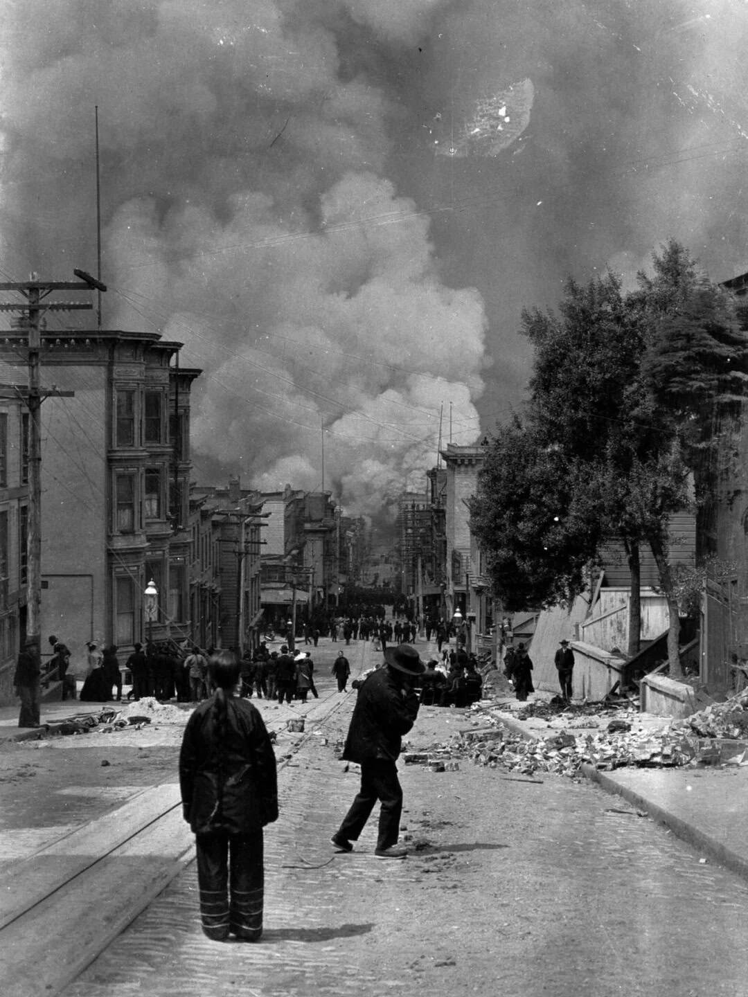 A street in San Francisco’s Chinatown with smoke rising in the distance, illustrating the challenges faced by Wuyi migrant communities after the 1906 earthquake.