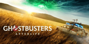 Ghostbusters: Afterlife scene with Ecto-1 vehicle in a field at sunset.