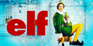 Elf character sitting on a chair in a festive Christmas scene with snow and holiday decorations.