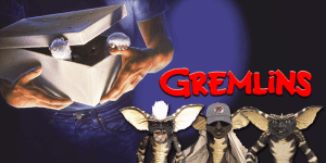 Close-up of Gremlins characters with a person holding a box from the Gremlins movie.