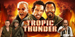 Three men dressed as characters from Tropic Thunder with fiery background.