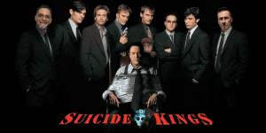 Group of men in suits with one seated, from Podcast 268: Suicide Kings.