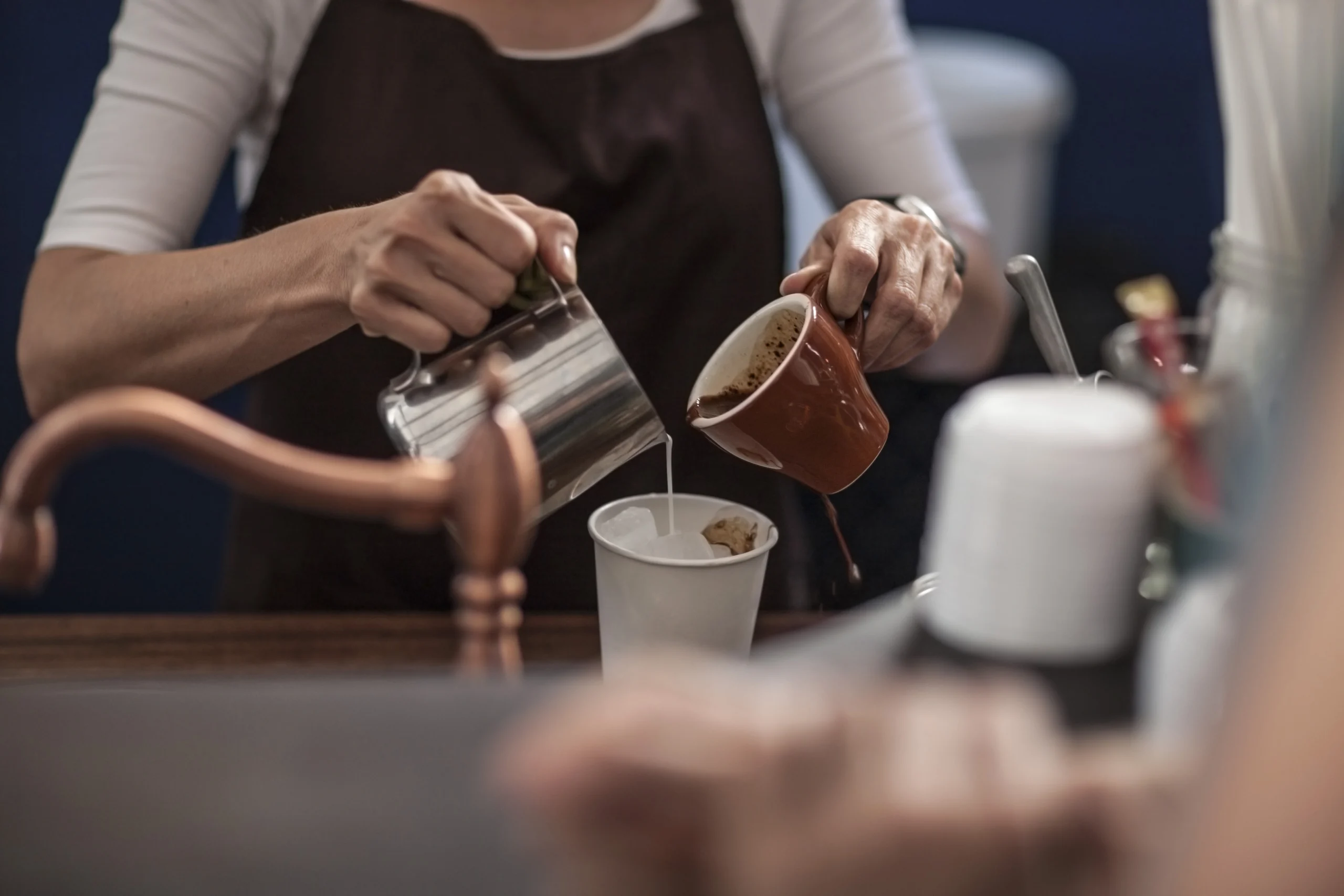 barista nalewa kawę do kubka