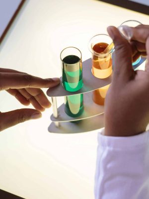 Crop laboratory technician in white uniform using pipette for taking sample from test tube during biochemical experiment in researching center