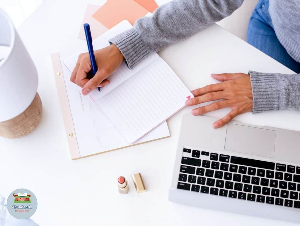lady behind her desk writing in her notebook to work through the 8 steps to set goals