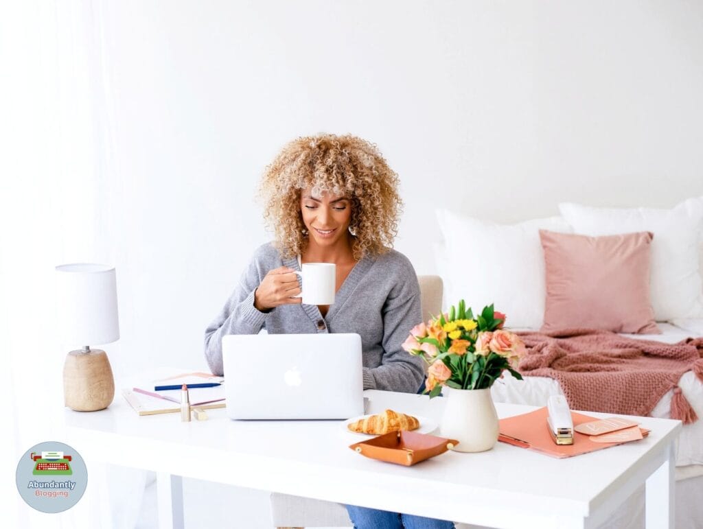lady behind her desk drinking a beverage and working through the 8 steps to set goals