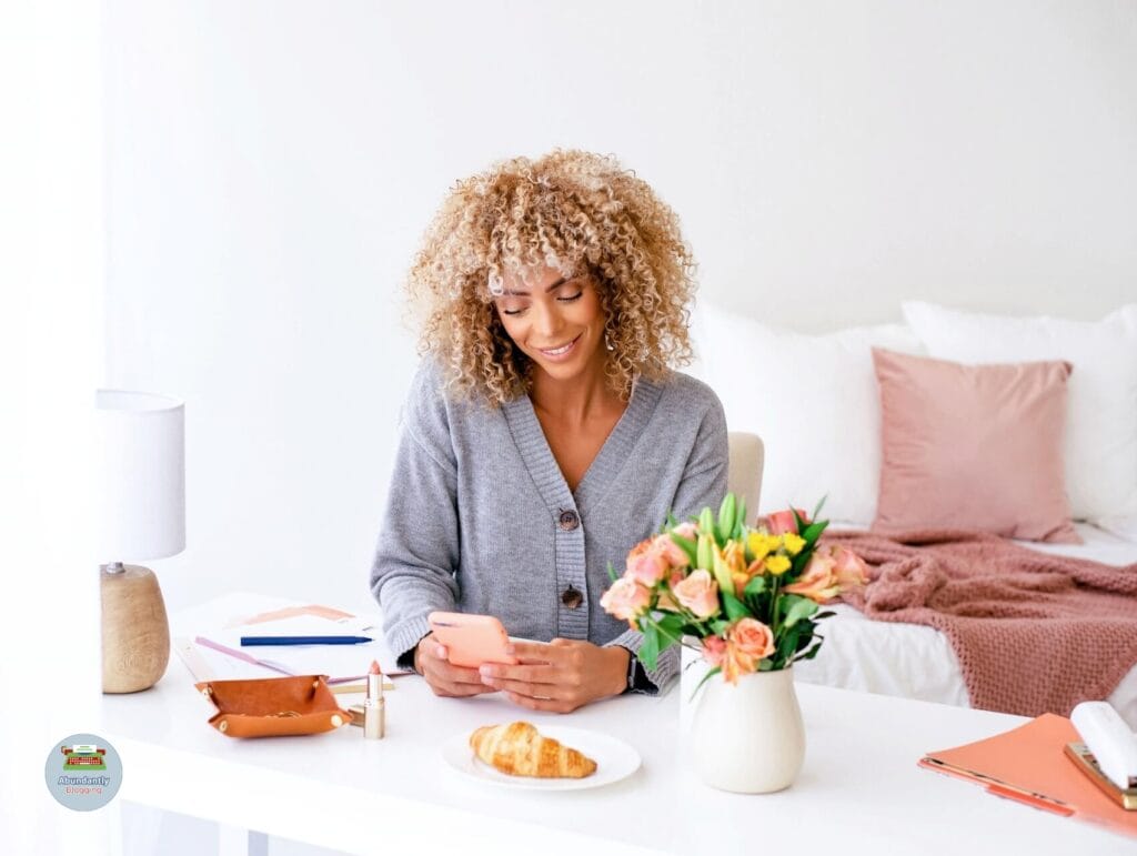 lady behind her desk with her phone and working through the 8 steps to set goals
