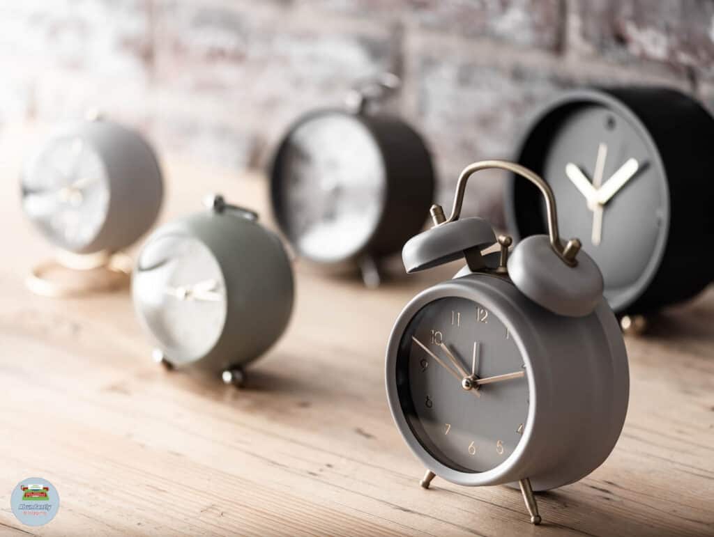 rustic wall, wooden side table, and 5 analog alarm clocks - pomodoro technique