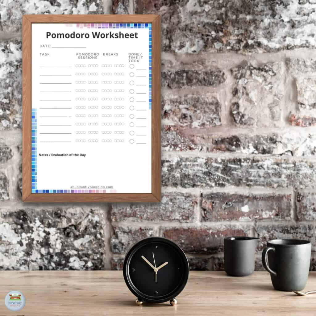 rustic wall, wooden table with a analog clock, two cups, and a wooden frame with the Pomodoro Technique Worksheet in it
