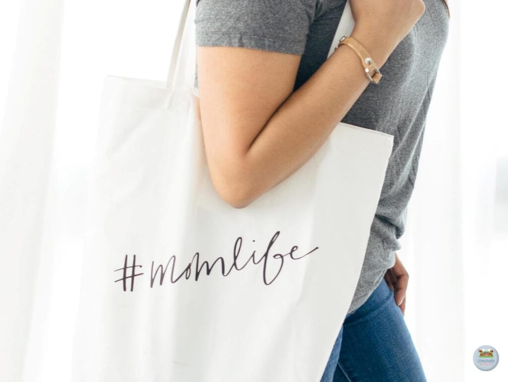 A mom with a bag over her shoulder that says # momlife - Benefits of Work-Life Balance