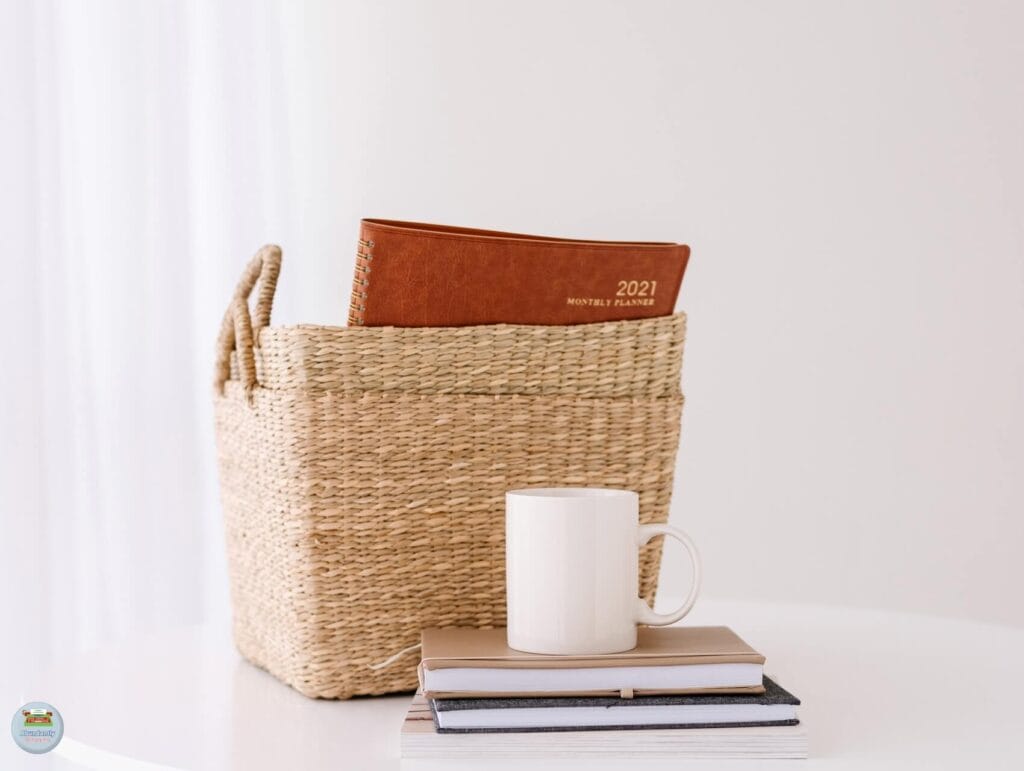 A white desk against the wall with 2 baskets, a couple of notebooks, a mug - 80/20 Rule in Blogging