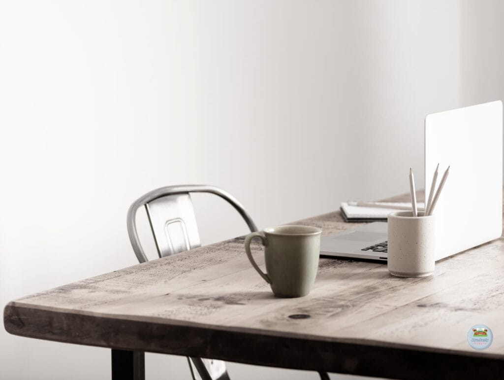 a minimalistic view of a wooden table and metal chair. on the table is an open laptop, a notebook and pen, a mug, and a holder with 3 pencils - How to repurpose