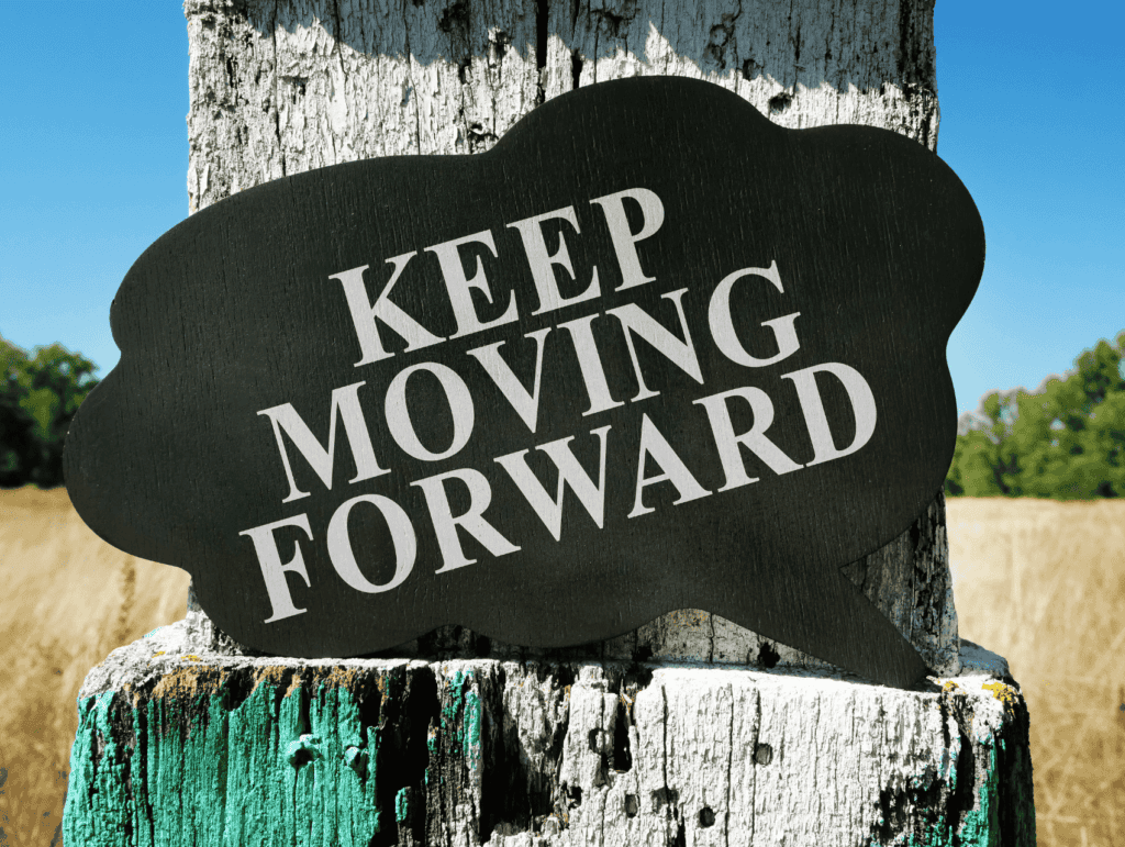 a thought-bubble in black on an old piece of wood saying "Keep moving forward" - celebrating blogging milestones