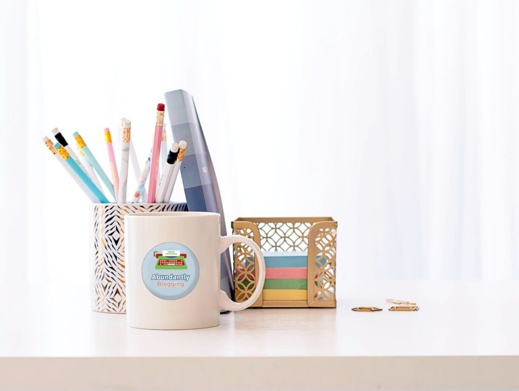 a desk with some office supplies like a cup with pencils, a little notebook, and post-it notes on it - setting goals for blogging growth