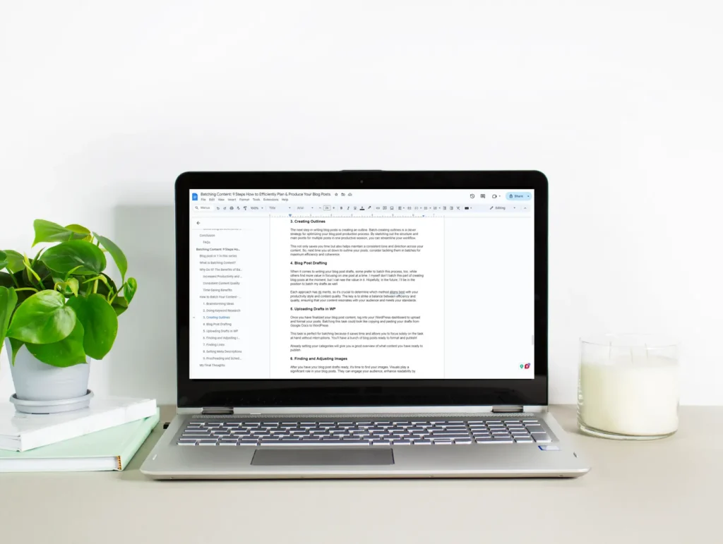 A laptop screen displaying a blog post draft with clear section headings and formatting, flanked by a lush philodendron plant and minimalist desk accessories - blogging toolkit