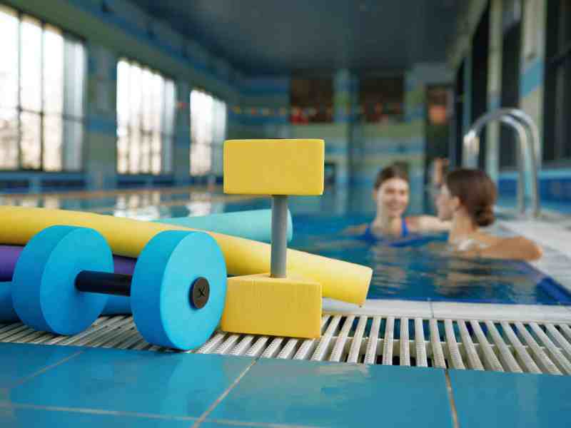 Aqua aerobics class gymnastics training lesson at health club with swimming pool