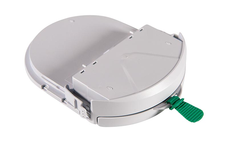 Round white plastic bidet attachment with green lever