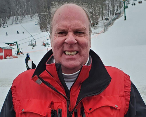 Man in red jacket at snowy ski resort