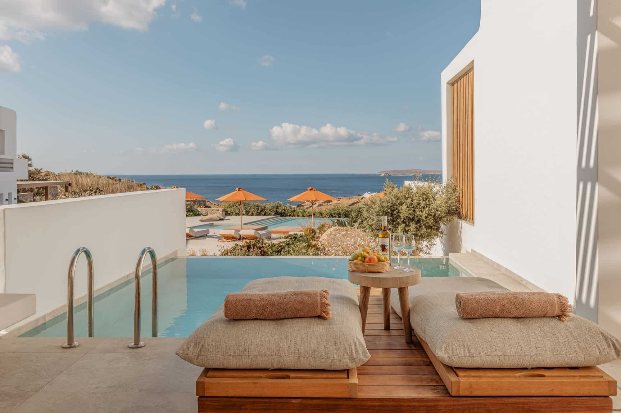 Stunning infinity pool overlooking the Aegean Sea with sun loungers and private terrace at Aelo Mykonos.