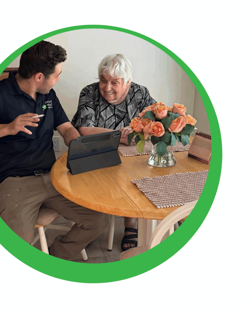 Man and woman looking at a tablet on a wooden table with flowers.