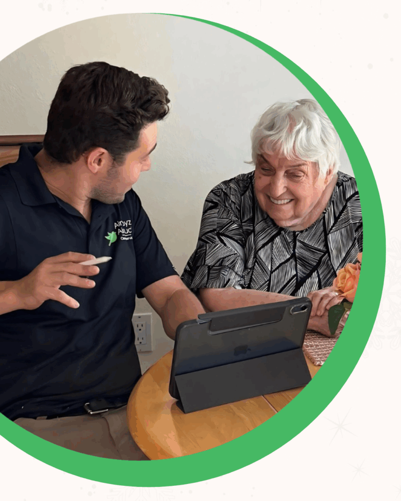 Man and woman smiling at a tablet on a wooden table