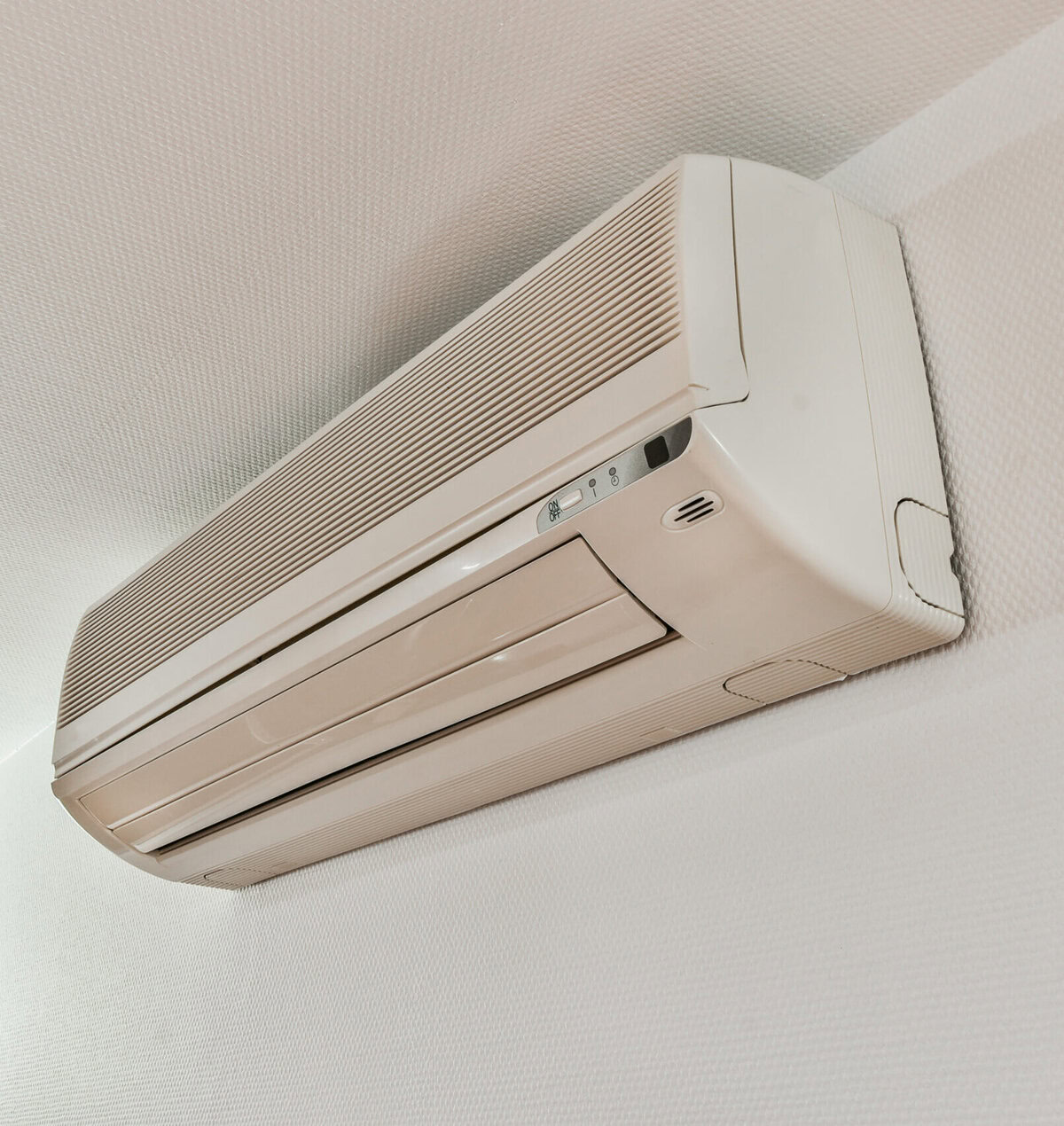 White air conditioning unit mounted on a textured white wall