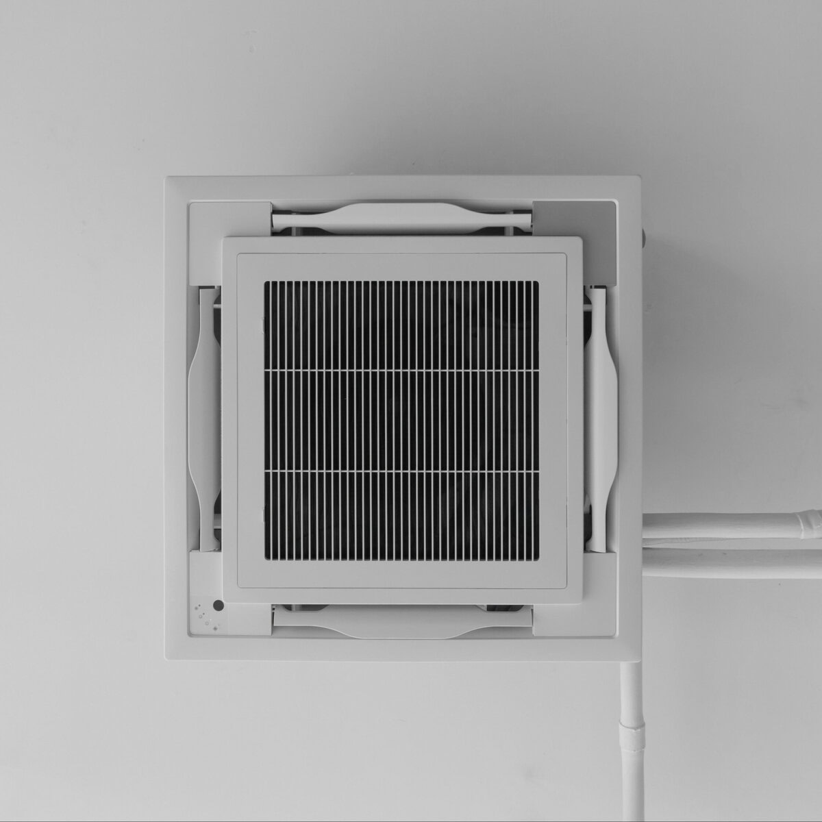 http://White%20ceiling-mounted%20air%20conditioner%20unit%20with%20a%20black%20grille