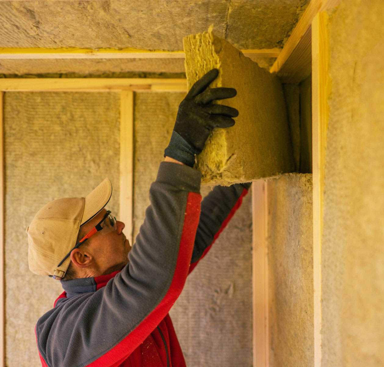 http://Man%20installing%20insulation%20in%20a%20wooden%20frame%20wall