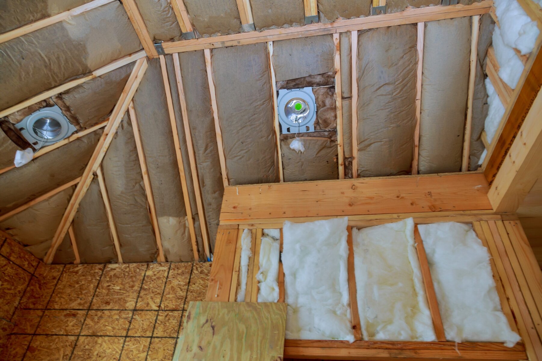 Attic insulation and wooden framing with two round vents