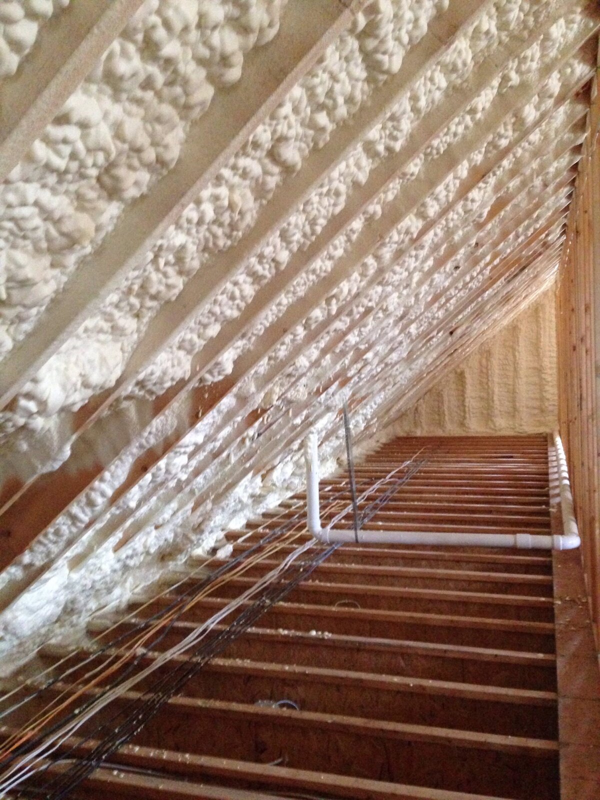 Spray foam insulation applied to the underside of a roof in an attic.