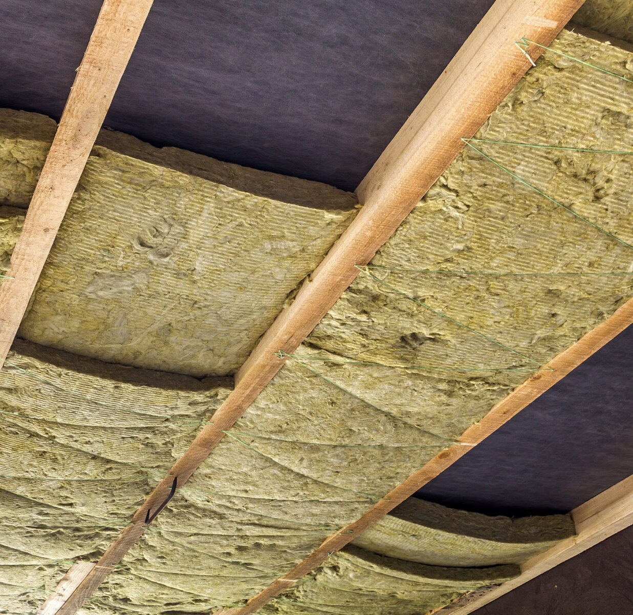 http://Close-up%20of%20rock%20wool%20insulation%20between%20wooden%20roof%20rafters