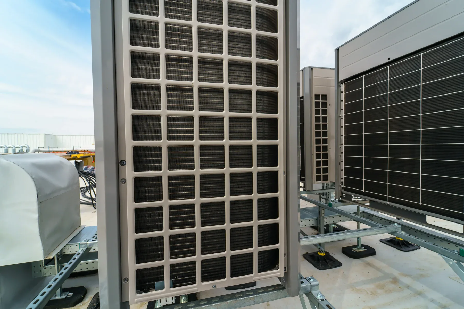 Outdoor air conditioning units on a rooftop under a blue sky.