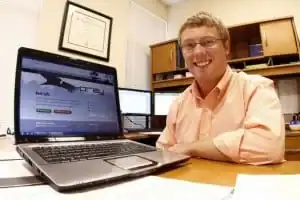 Man working on cybersecurity with multiple monitors at Allevia Technology.