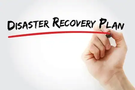 Hand writing 'Disaster Recovery Plan' on whiteboard with red underline.