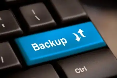 Blue backup button on a computer keyboard for data protection.