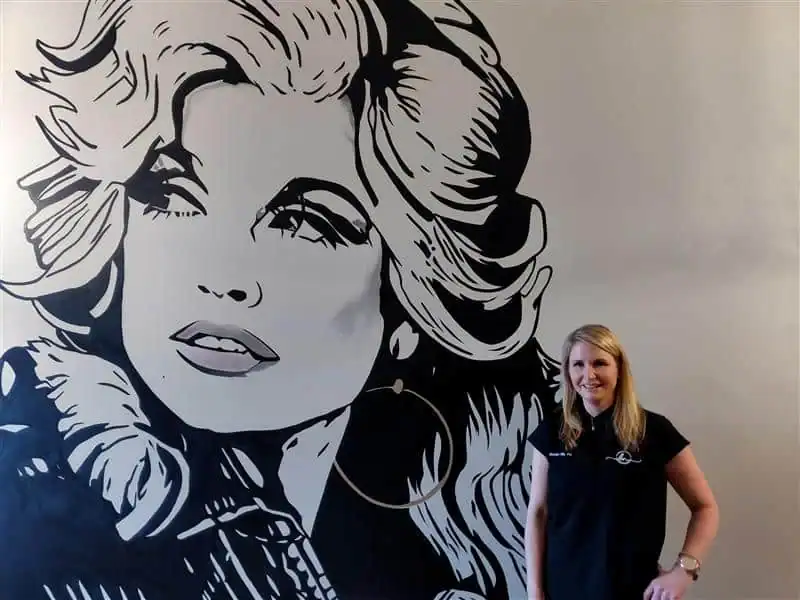Brooke Nix standing next to a large Marilyn Monroe mural at Allevia Technology.