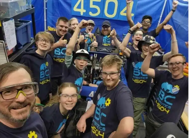 Students and mentors celebrate at a robotics competition with BC Robotics 4504.