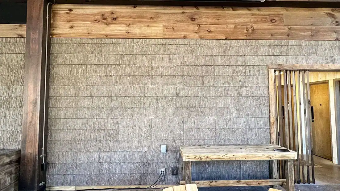 Outdoor TV wall setup at Little Arrow Outdoor Resort with wooden accents.